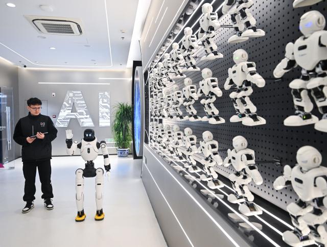 (251205) -- BEIJING, Dec. 5, 2025 (Xinhua) -- A humanoid robot greets people at an AI industry center in Nanjing, east China's Jiangsu Province, Dec. 4, 2025. (Xinhua/Ji Chunpeng)