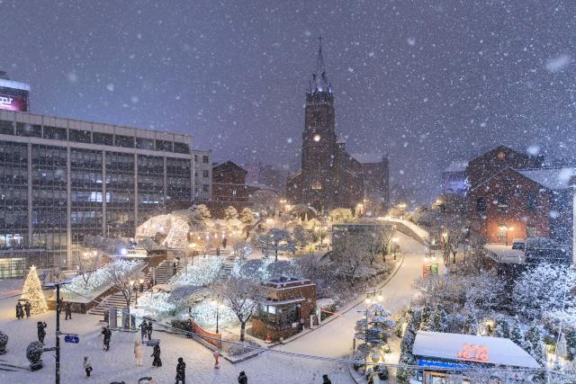 (251205) -- SEOUL, Dec. 5, 2025 (Xinhua) -- People walk in snow in Seoul, South Korea, on Dec. 4, 2025. Seoul on Thursday saw its first snowfall of this year. (Photo by Park Jintaek/Xinhua)