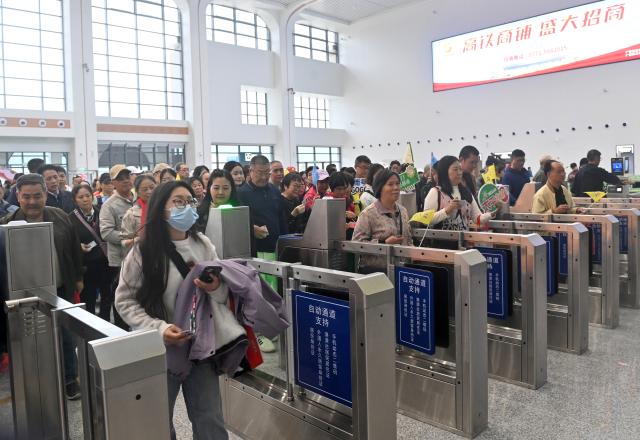 (251205) -- NANNING, Dec. 5, 2025 (Xinhua) -- Passengers pass through the ticket gates at Pingxiang East Railway Station, in Pingxiang City, south China's Guangxi Zhuang Autonomous Region, on Dec. 5, 2025. The Chongzuo-Pingxiang section of the Nanning-Pingxiang Railway began operation on Friday, marking the full operation of the high-speed railway, which connects the region's capital city Nanning to the border city Pingxiang. (Xinhua/Lu Boan)