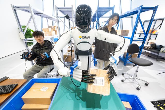 (251205) -- WUHAN, Dec. 5, 2025 (Xinhua) -- Staff members operate a robot to collect data in a warehouse scenario at a humanoid robot innovation center in Wuhan East Lake High-tech Development Zone, also known as the optics valley of China, in Wuhan, central China's Hubei Province, Dec. 4, 2025. Relying on its scientific and educational resources as well as manufacturing advantages, Hubei is accelerating the layout of its humanoid robot industry chain this year. 
   At present, there are many complete humanoid robot manufacturers as well as core components enterprises in the province, covering core technologies such as chips, joints and dexterous hands. 
   The province has also established a humanoid robot innovation center, providing services for humanoid robot enterprises to carry out research and development such as concept and scenario verification as well as data integration, promoting the in-depth integration of scientific and technological innovation and industrial innovation. (Xinhua/Xiao Yijiu)