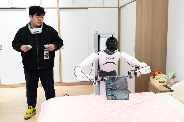 (251205) -- WUHAN, Dec. 5, 2025 (Xinhua) -- A staff member operates a robot to collect data in a home life scenario at a humanoid robot innovation center in Wuhan East Lake High-tech Development Zone, also known as the optics valley of China, in Wuhan, central China's Hubei Province, Dec. 4, 2025. Relying on its scientific and educational resources as well as manufacturing advantages, Hubei is accelerating the layout of its humanoid robot industry chain this year. 
   At present, there are many complete humanoid robot manufacturers as well as core components enterprises in the province, covering core technologies such as chips, joints and dexterous hands. 
   The province has also established a humanoid robot innovation center, providing services for humanoid robot enterprises to carry out research and development such as concept and scenario verification as well as data integration, promoting the in-depth integration of scientific and technological innovation and industrial innovation. (Xinhua/Xiao Yijiu)