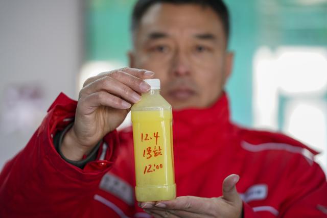 (251205) -- DAQING, Dec. 5, 2025 (Xinhua) -- A staff member presents a shale oil sample at a national-level demonstration zone of continental shale oil of Daqing Oilfield in Daqing, northeast China's Heilongjiang Province, Dec. 4, 2025. Daqing Oilfield, one of China's largest energy production bases, announced Friday that the yearly output of the shale oil in the demonstration zone has exceeded one million tonnes. (Xinhua/Wang Song)