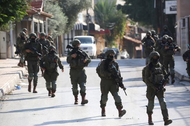 (251205) -- QALQILYA, Dec. 5, 2025 (Xinhua) -- Israeli soldiers are seen during a military operation in the West Bank city of Qalqilya, Dec. 4, 2025. Israeli forces expanded their military campaign in the northern West Bank on Thursday, imposing a tight cordon on the Kafr Saba neighborhood in Qalqilya and restricting Palestinian movement in the area. (Photo by Nidal Eshtayeh/Xinhua)