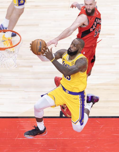 (251205) -- TORONTO, Dec. 5, 2025 (Xinhua) -- LeBron James (Front) of Los Angeles Lakers goes for a layup during the 2025-2026 NBA regular season game between Toronto Raptors and Los Angeles Lakers in Toronto, Canada, on Dec. 4, 2025. (Photo by Zou Zheng/Xinhua)
