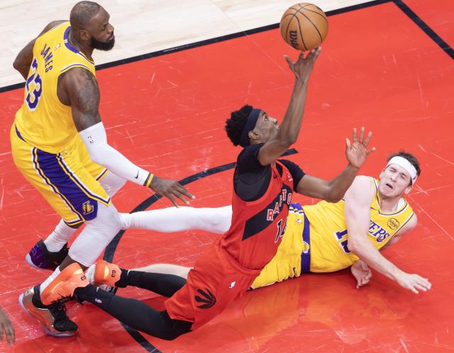 (251205) -- TORONTO, Dec. 5, 2025 (Xinhua) -- Ja'Kobe Walter (C) of Toronto Raptors goes for a layup during the 2025-2026 NBA regular season game between Toronto Raptors and Los Angeles Lakers in Toronto, Canada, on Dec. 4, 2025. (Photo by Zou Zheng/Xinhua)
