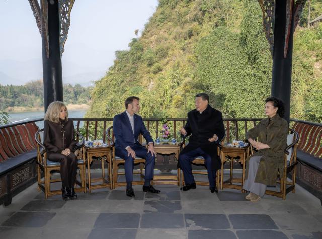 (251205) -- CHENGDU, Dec. 5, 2025 (Xinhua) -- Chinese President Xi Jinping and his wife Peng Liyuan, together with French President Emmanuel Macron and his wife Brigitte Macron, take seats at Huaigu Pavilion, where they enjoy tea by the waterside and hold wide-ranging discussions on global affairs, in Dujiangyan of Chengdu, southwest China's Sichuan Province, Dec. 5, 2025. Xi and Macron had friendly exchanges on Friday in Dujiangyan. (Xinhua/Zhai Jianlan)