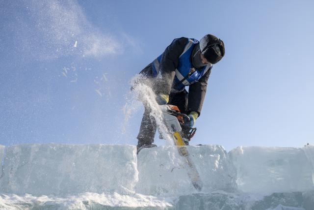 (251205) -- HARBIN, Dec. 5, 2025 (Xinhua) -- A worker operates with a chainsaw at the construction site of Ice and Snow World in Harbin, northeast China's Heilongjiang Province, Dec. 5, 2025. The 27th edition of Ice and Snow World in Harbin has recently kicked off its construction work, which involves more than 10,000 workers and about 1,000 machines. The park area is expected to be extended to 1.2 million square meters, the largest of all editions in history. (Xinhua/Zhang Tao)
