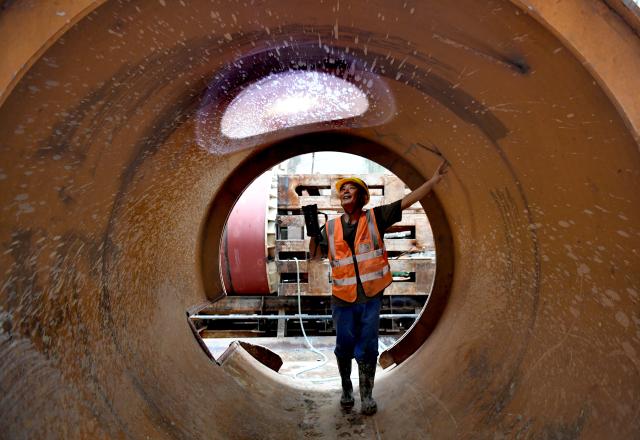 (251205) -- SANYA, Dec. 5, 2025 (Xinhua) -- A staff member works at the construction site of the Sanya River estuary passage project in Sanya, south China's Hainan Province, Dec. 5, 2025. The Sanya River estuary passage project undertaken by China Railway 20th Bureau Group was successfully drilled through on Friday. This 3.118-kilometer underwater tunnel, the first of its kind in Sanya, is expected to further optimize the urban spatial layout of the city, and facilitate the development of the Hainan Free Trade Port. (Xinhua/Zhao Yingquan)