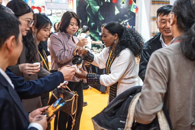 (251205) -- PU'ER, Dec. 5, 2025 (Xinhua) -- People taste Ethiopian coffee at the 2025 China (Pu'er) International Coffee Expo and Pu'er Tea Expo & Trade Fair in Pu'er, southwest China's Yunnan Province, Dec. 5, 2025. The three-day dual-expo event kicked off here on Friday, attracting over 100 enterprises from home and abroad. (Xinhua/Wang Guansen)