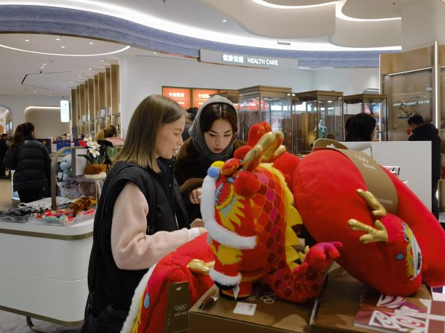 (251205) -- TIANJIN, Dec. 5, 2025 (Xinhua) -- Two Russian consumers view products related with "Guochao", or "China chic", in Tianjin, north China, Nov. 28, 2025. TO GO WITH "China Focus: From tea sets to tech, China-chic captivates global consumers" (Xinhua/Song Rui)