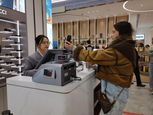 (251205) -- TIANJIN, Dec. 5, 2025 (Xinhua) -- Marta Rybakova shops at a newly opened downtown duty-free shop in Tianjin, north China, Nov. 28, 2025. TO GO WITH "China Focus: From tea sets to tech, China-chic captivates global consumers" (Xinhua/Song Rui)