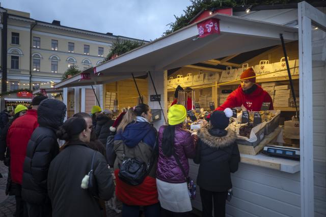 (251205) -- HELSINKI, Dec. 5, 2025 (Xinhua) -- People buy sweets at Helsinki Christmas Market in Helsinki, Finland, on Dec. 5, 2025. Held in Senate Square in the heart of the city, the Helsinki Christmas Market is a historic outdoor Christmas fair that attracts large numbers of visitors every year. This year's Market is open from Nov. 28 to Dec. 22. (Photo by Matti Matikainen/Xinhua)