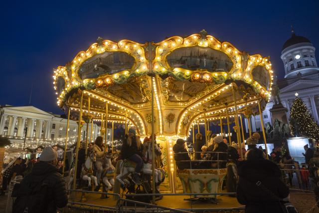 (251205) -- HELSINKI, Dec. 5, 2025 (Xinhua) -- People ride a carousel at Helsinki Christmas Market in Helsinki, Finland, on Dec. 5, 2025. Held in Senate Square in the heart of the city, the Helsinki Christmas Market is a historic outdoor Christmas fair that attracts large numbers of visitors every year. This year's Market is open from Nov. 28 to Dec. 22. (Photo by Matti Matikainen/Xinhua)