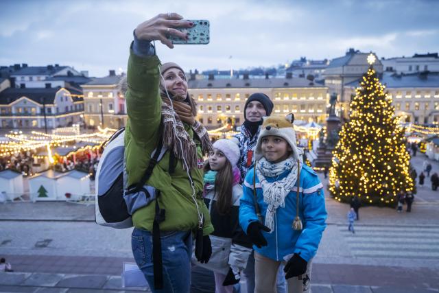 (251205) -- HELSINKI, Dec. 5, 2025 (Xinhua) -- People take selfie at Helsinki Christmas Market in Helsinki, Finland, on Dec. 5, 2025. Held in Senate Square in the heart of the city, the Helsinki Christmas Market is a historic outdoor Christmas fair that attracts large numbers of visitors every year. This year's Market is open from Nov. 28 to Dec. 22. (Photo by Matti Matikainen/Xinhua)