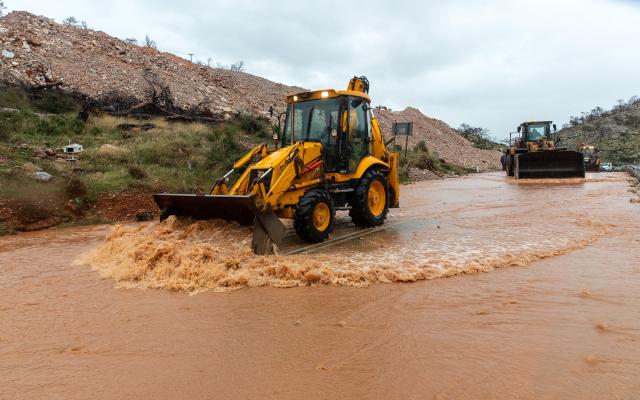 (251205) -- MANDRA, Dec. 5, 2025 (Xinhua) -- People operate heavy machinery to clear a flooded road in Mandra, in western Attica, about 20 kilometers west of central Athens, Greece, Dec. 5, 2025. A powerful storm, named Byron by local meteorologists, continued to batter Greece for a second consecutive day on Friday, triggering widespread flooding. (Photo by Marios Lolos/Xinhua)