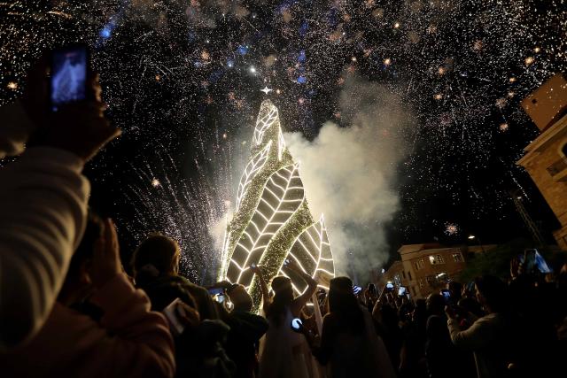 (251205) -- BYBLOS, Dec. 5, 2025 (Xinhua) -- People gather in front of a Christmas tree and festive decorations in the city of Byblos, Lebanon, Dec. 5, 2025. (Xinhua/Bilal Jawich)