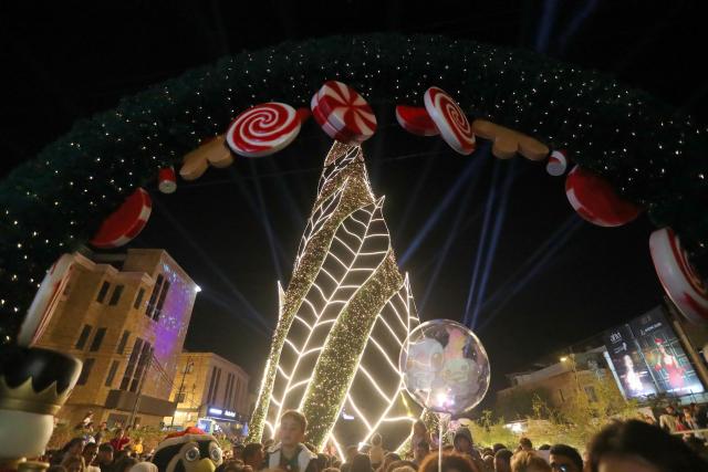(251205) -- BYBLOS, Dec. 5, 2025 (Xinhua) -- People gather in front of a Christmas tree and festive decorations in the city of Byblos, Lebanon, Dec. 5, 2025. (Xinhua/Bilal Jawich)