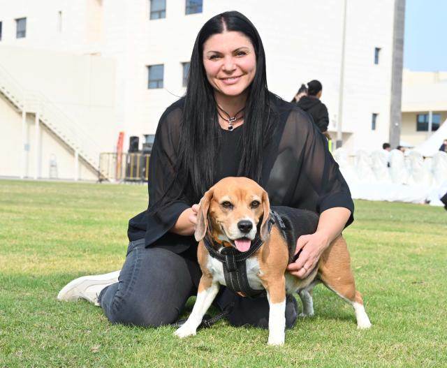 (251205) -- HAWALLI GOVERNORATE, Dec. 5, 2025 (Xinhua) -- A pet dog is pictured with its owner at a dog show in Hawalli Governorate, Kuwait, Dec. 5, 2025. The Kuwait National Dog Show kicked off recently. The show will last 3 days until Dec. 6. (Photo by Asad/Xinhua)