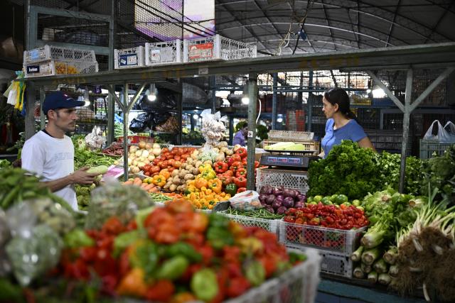 (251205) -- CARACAS, Dec. 5, 2025 (Xinhua) -- A customer buys vegetable at Quinta Crespo Market, which is one of the city's famous and traditional municipal markets, in Caracas, Venezuela, Dec. 5, 2025. (Xinhua/Li Muzi)