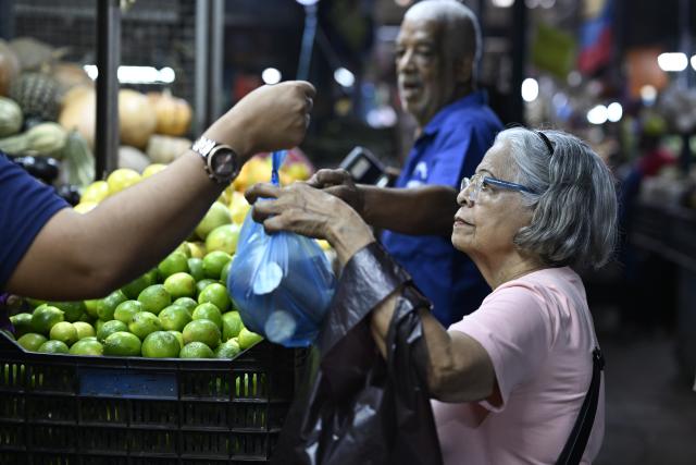 (251205) -- CARACAS, Dec. 5, 2025 (Xinhua) -- A customer buys vegetable at Quinta Crespo Market, which is one of the city's famous and traditional municipal markets, in Caracas, Venezuela, Dec. 5, 2025. (Xinhua/Li Muzi)