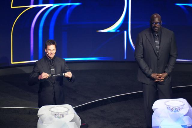 (251206) -- WASHINGTON D.C., Dec. 6, 2025 (Xinhua) -- Draw assistant Tom Brady (L) holds the ticket of Germany during the FIFA World Cup 2026 Final Draw at the Kennedy Center in Washington D.C., the United States, Dec. 5, 2025. (Xinhua/Wu Xiaoling)