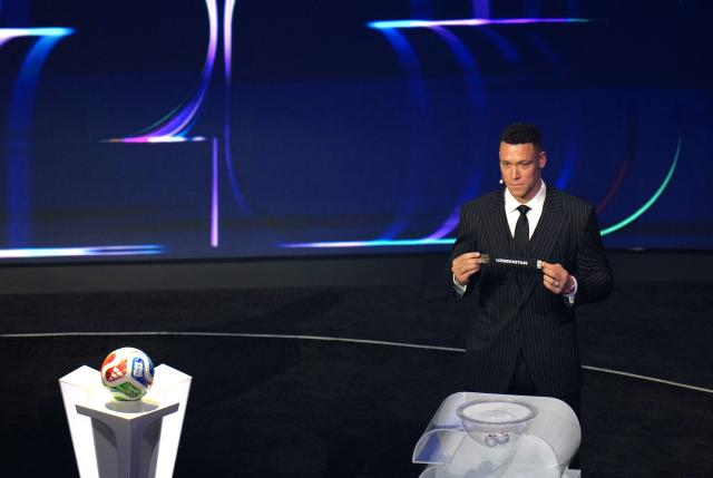 (251206) -- WASHINGTON D.C., Dec. 6, 2025 (Xinhua) -- Draw assistant Aaron Judge holds the ticket of Uzbekistan during the FIFA World Cup 2026 Final Draw at the Kennedy Center in Washington D.C., the United States, Dec. 5, 2025. (Xinhua/Wu Xiaoling)