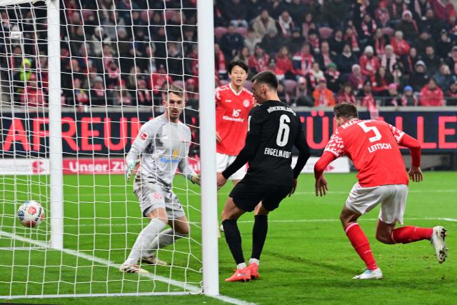 (251206) -- MAINZ, Dec. 6, 2025 (Xinhua) -- Maxim Leitsch (1st R) of FSV Mainz 05 scores an own goal which is ruled out due to a handball in the play by Yannik Engelhardt (2nd R) of Borussia Moenchengladbach during the German first division Bundesliga football match between FSV Mainz 05 and Borussia Moenchengladbach in Mainz, Germany, Dec. 5, 2025. (Photo by Ulrich Hufnagel/Xinhua)