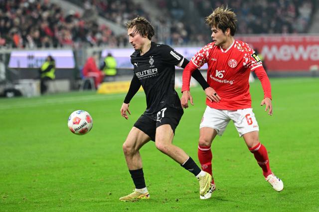 (251206) -- MAINZ, Dec. 6, 2025 (Xinhua) -- Kaishu Sano (R) of FSV Mainz 05 vies with Rocco Reitz of Borussia Moenchengladbach during the German first division Bundesliga football match between FSV Mainz 05 and Borussia Moenchengladbach in Mainz, Germany, Dec. 5, 2025. (Photo by Ulrich Hufnagel/Xinhua)