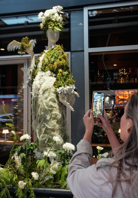 (251206) -- VANCOUVER, Dec. 6, 2025 (Xinhua) -- A resident takes photographs of a floral mannequin displayed on the street during the Fleurs de Villes NOËL event in Vancouver, British Columbia, Canada, on Dec. 5, 2025. Featuring 30 stunning floral installations created by local floral artists to celebrate the holiday season, this annual event exhibition kicked off here on Friday and will run until December 14. (Photo by Liang Sen/Xinhua)