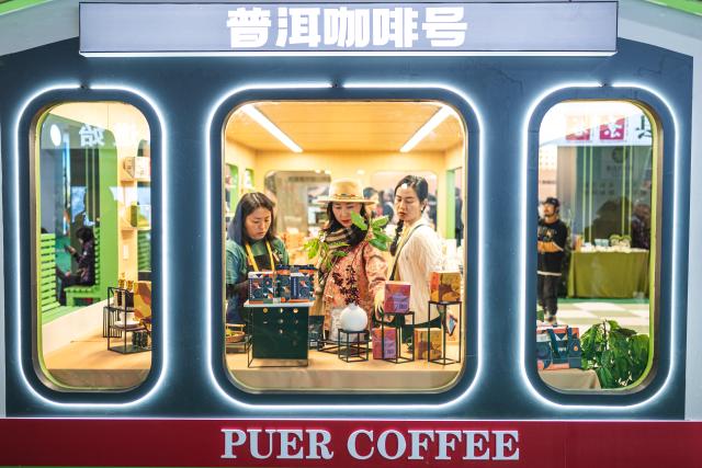 (251206) -- BEIJING, Dec. 6, 2025 (Xinhua) -- People view coffee products displayed at the 2025 China (Pu'er) International Coffee Expo and Pu'er Tea Expo & Trade Fair in Pu'er, southwest China's Yunnan Province, Dec. 5, 2025. The three-day dual-expo event kicked off here on Friday, attracting over 100 enterprises from home and abroad. (Xinhua/Wang Guansen)
