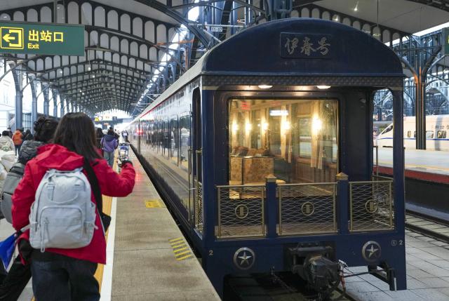 (251206) -- HARBIN, Dec. 6, 2025 (Xinhua) -- A tourist train dubbed Yichun is seen at Harbin Railway Station in Harbin, northeast China's Heilongjiang Province, Dec. 6, 2025. A tourist train dubbed Yichun began trial operation on Saturday. More than 40 invited passengers boarded the train at Harbin Railway Station for a trip bound to Yabuli Ski Resort. The train features five themed carriages and offers live band and traditional folk performances for passengers. (Xinhua/Wang Song)