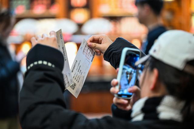 (251206) -- TIANJIN, Dec. 6, 2025 (Xinhua) -- Audience take photos of tickets of Xiangsheng, or crosstalk comedy, at a tea house in north China's Tianjin, Dec. 4, 2025. Crosstalk comedy is a popular form of entertainment for citizens in Tianjin. (Xinhua/Zhao Zishuo)