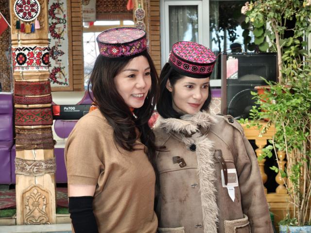 (251206) -- URUMQI, Dec. 6, 2025 (Xinhua) -- Banafsha Memetituheti (R) poses for photos with a tourist at a homestay in Tajik Autonomous County of Taxkorgan, northwest China's Xinjiang Uygur Autonomous Region, Oct. 29, 2025. TO GO WITH "China Focus: In China's far west, young entrepreneurs are brewing a new future" (Xinhua)