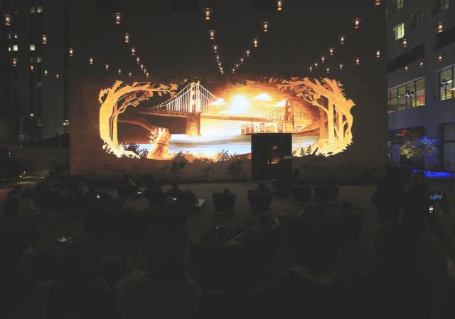 (251206) -- SAN FRANCISCO, Dec. 6, 2025 (Xinhua) -- People watch a light projection on the wall of a building in San Francisco, the United States, Dec. 5, 2025. "Let's Glow SF", a holiday projection arts event, started here on Friday night. Large-scale art projection works will be displayed on the facades of eight iconic buildings in downtown San Francisco from the night of Dec. 5 to 14. (Photo by Liu Yilin/Xinhua)