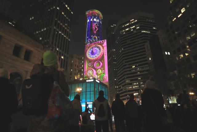 (251206) -- SAN FRANCISCO, Dec. 6, 2025 (Xinhua) -- People watch a light projection on the wall of a building in San Francisco, the United States, Dec. 5, 2025. "Let's Glow SF", a holiday projection arts event, started here on Friday night. Large-scale art projection works will be displayed on the facades of eight iconic buildings in downtown San Francisco from the night of Dec. 5 to 14. (Photo by Liu Yilin/Xinhua)