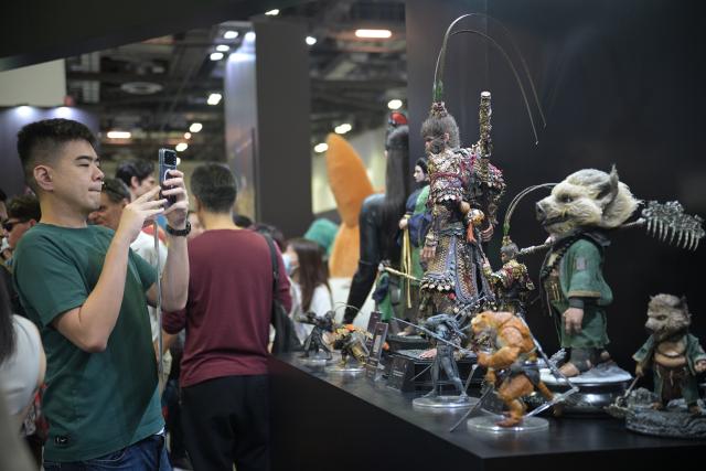 (251206) -- SINGAPORE, Dec. 6, 2025 (Xinhua) -- A man takes photos of various merchandise during the Singapore Comic Con in Singapore on Dec. 6, 2025. The event opened here on Saturday. (Photo by Then Chih Wey/Xinhua)