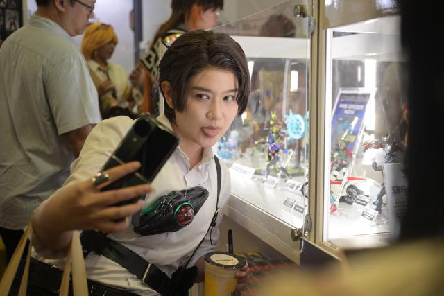 (251206) -- SINGAPORE, Dec. 6, 2025 (Xinhua) -- A dressed-up cosplayer poses for selfies during the Singapore Comic Con in Singapore on Dec. 6, 2025. The event opened here on Saturday. (Photo by Then Chih Wey/Xinhua)