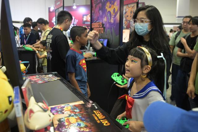 (251206) -- SINGAPORE, Dec. 6, 2025 (Xinhua) -- A girl plays a game designed in Singapore during the Singapore Comic Con in Singapore on Dec. 6, 2025. The event opened here on Saturday. (Photo by Then Chih Wey/Xinhua)
