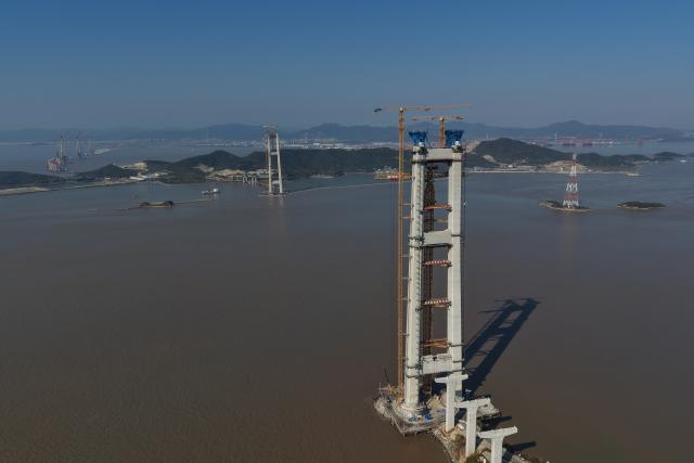 (251206) -- ZHOUSHAN, Dec. 6, 2025 (Xinhua) -- A drone photo shows the construction site of the Shuangyumen super major bridge in east China's Zhejiang Province, Dec. 6, 2025. The pilot cable installation for the Shuangyumen super major bridge, part of the second phase of the Liuheng Highway Bridge project at Ningbo-Zhoushan Port in Zhejiang Province, completed successfully on Saturday. This marks the official commencement of the catway construction on the bridge.
   The project consists of two sea-crossing bridges - Shuangyumen super major bridge and Qinglongmen super major bridge, as well as connection lines between them. Upon completion, the project will further improve the integrated land-sea transportation network of Ningbo-Zhoushan Port. (Xinhua/Huang Zongzhi)