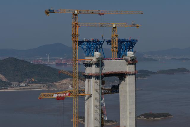 (251206) -- ZHOUSHAN, Dec. 6, 2025 (Xinhua) -- A drone photo shows the construction site of the Shuangyumen super major bridge in east China's Zhejiang Province, Dec. 6, 2025. The pilot cable installation for the Shuangyumen super major bridge, part of the second phase of the Liuheng Highway Bridge project at Ningbo-Zhoushan Port in Zhejiang Province, completed successfully on Saturday. This marks the official commencement of the catway construction on the bridge.
   The project consists of two sea-crossing bridges - Shuangyumen super major bridge and Qinglongmen super major bridge, as well as connection lines between them. Upon completion, the project will further improve the integrated land-sea transportation network of Ningbo-Zhoushan Port. (Xinhua/Huang Zongzhi)