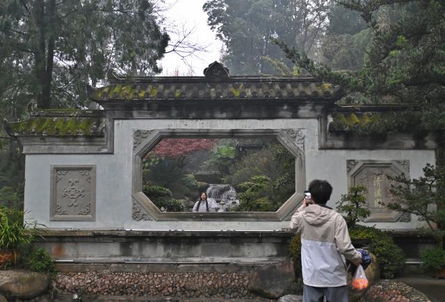 (251206) -- CHENGDU, Dec. 6, 2025 (Xinhua) -- Tourists visit Qingxi Garden at Dujiangyan scenic area in Chengdu, southwest China's Sichuan Province, Dec. 6, 2025. The Dujiangyan irrigation system, characterized by dam-free water diversion, was built in 256 BC and is the oldest, the only remaining grand water conservancy project in the world, which has withstood the tests of natural disasters such as floods and earthquakes, and is still in use today. 
   A "fish-mouth" shaped weir splits the Minjiang River into an inner channel for irrigation and an outer channel for discharge of flood water. 
   It was listed as a World Cultural Heritage by the United Nations in November 2000, and was listed as a World Irrigation Engineering Heritage in August 2018. (Xinhua/Liu Kun)