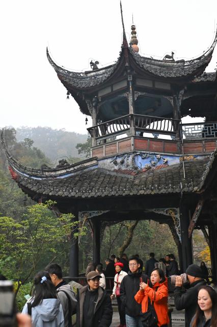 (251206) -- CHENGDU, Dec. 6, 2025 (Xinhua) -- Tourists visit Huaigu Pavilion of Fulongguan at Dujiangyan scenic area in Chengdu, southwest China's Sichuan Province, Dec. 6, 2025. The Dujiangyan irrigation system, characterized by dam-free water diversion, was built in 256 BC and is the oldest, the only remaining grand water conservancy project in the world, which has withstood the tests of natural disasters such as floods and earthquakes, and is still in use today. 
   A "fish-mouth" shaped weir splits the Minjiang River into an inner channel for irrigation and an outer channel for discharge of flood water. 
   It was listed as a World Cultural Heritage by the United Nations in November 2000, and was listed as a World Irrigation Engineering Heritage in August 2018. (Xinhua/Liu Kun)