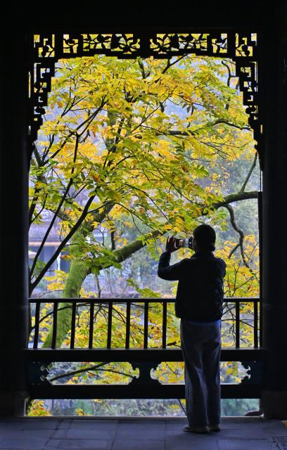 (251206) -- CHENGDU, Dec. 6, 2025 (Xinhua) -- A tourist takes photos at Fulongguan in Dujiangyan scenic area in Chengdu, southwest China's Sichuan Province, Dec. 6, 2025. The Dujiangyan irrigation system, characterized by dam-free water diversion, was built in 256 BC and is the oldest, the only remaining grand water conservancy project in the world, which has withstood the tests of natural disasters such as floods and earthquakes, and is still in use today. 
   A "fish-mouth" shaped weir splits the Minjiang River into an inner channel for irrigation and an outer channel for discharge of flood water. 
   It was listed as a World Cultural Heritage by the United Nations in November 2000, and was listed as a World Irrigation Engineering Heritage in August 2018. (Xinhua/Liu Kun)