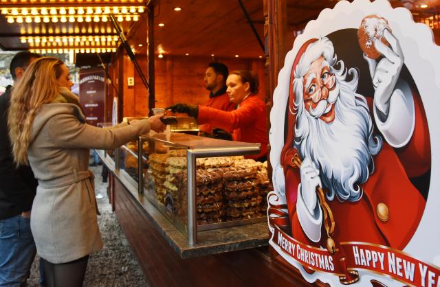 (251207) -- THE HAGUE, Dec. 7, 2025 (Xinhua) -- A woman buys food at the Royal Christmas Fair in The Hague, the Netherlands, Dec. 6, 2025. Kicking off here on Dec. 4, the fair will run until Dec. 23. (Xinhua/Shao Haijun)