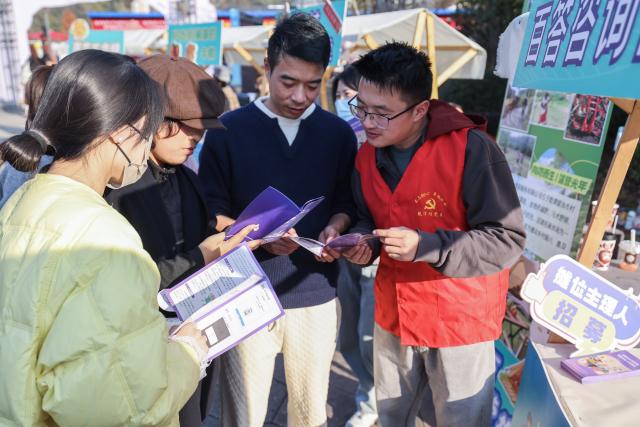 (251207) -- JIANDE, Dec. 7, 2025 (Xinhua) -- Visitors are briefed by a volunteer on relevant policies encouraging young people to work in rural areas and offering support for entrepreneurship at a talent market during a farmers' fair in Qiantan Town of Jiande City, east China's Zhejiang Province, Dec. 6, 2025. The farmers' fair kicked off here in Qiantan Town of Jiande City on Saturday. Over 300 stalls line up along a riverside walkway spanning nearly two kilometers, with a wide variety of daily necessities, agricultural products, local snacks, children's toys and more on display. 
   As the liveliest such event held at the end of the year in the area, the ongoing farmers' fair also features elements such as cultural performances and talent market. (Xinhua/Xu Yu)