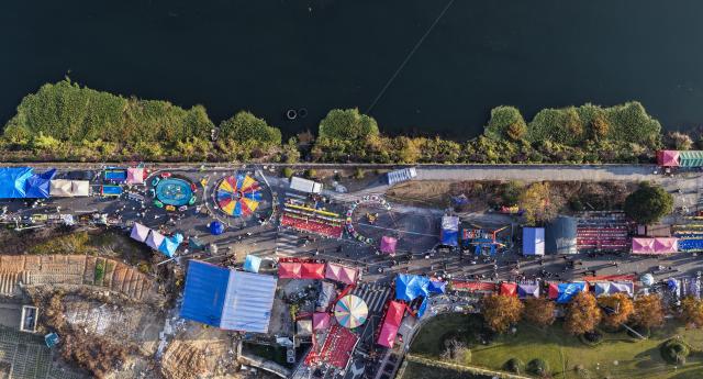(251207) -- JIANDE, Dec. 7, 2025 (Xinhua) -- An aerial drone photo taken on Dec. 6, 2025 shows a view of a farmers' fair in Qiantan Town of Jiande City, east China's Zhejiang Province. The farmers' fair kicked off here in Qiantan Town of Jiande City on Saturday. Over 300 stalls line up along a riverside walkway spanning nearly two kilometers, with a wide variety of daily necessities, agricultural products, local snacks, children's toys and more on display. 
   As the liveliest such event held at the end of the year in the area, the ongoing farmers' fair also features elements such as cultural performances and talent market. (Xinhua/Xu Yu)