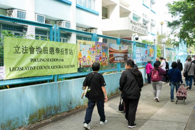 (251207) -- HONG KONG, Dec. 7, 2025 (Xinhua) -- Citizens arrive at a polling station in Tai Po of Hong Kong, south China, Dec. 7, 2025. Voting for the election of the eighth-term Legislative Council (LegCo) of China's HKSAR kicked off Sunday morning. (Xinhua/Zhu Wei)