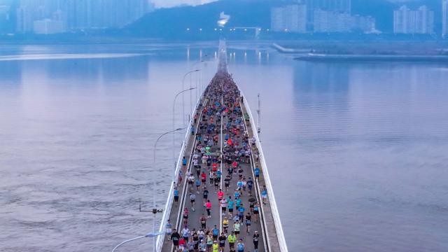 (251207) -- MACAO, Dec. 7, 2025 (Xinhua) -- An aerial drone photo taken on Dec. 7, 2025 shows competitors running through a bridge during the Macao International Marathon 2025 in Macao, South China. (Xinhua)