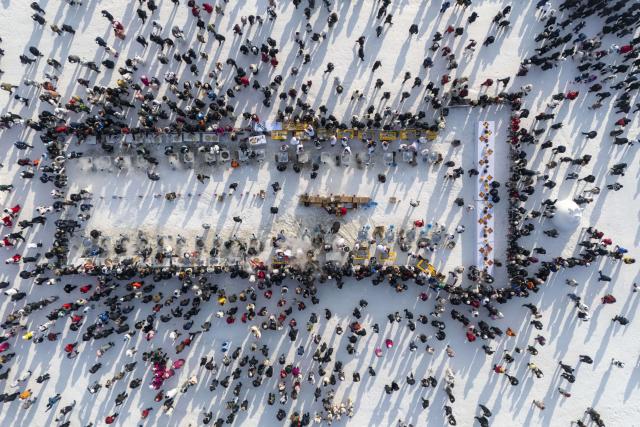 (251207) -- HARBIN, Dec. 7, 2025 (Xinhua) -- An aerial drone photo taken on Dec. 7, 2025 shows people tasting food at an ice collecting festival in Harbin, northeast China's Heilongjiang Province. Marking the beginning of Harbin's ice collecting season, the sixth ice collecting festival kicked off here by the Songhua River on Sunday, attracting lots of people with ice collecting ceremony and folk custom experience activities. (Xinhua/Zhang Tao)