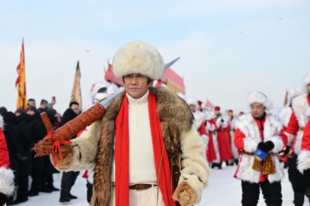 (251207) -- HARBIN, Dec. 7, 2025 (Xinhua) -- Crew members transport the first ice cube collected during an ice collecting festival in Harbin, northeast China's Heilongjiang Province, Dec. 7, 2025. Marking the beginning of Harbin's ice collecting season, the sixth ice collecting festival kicked off here by the Songhua River on Sunday, attracting lots of people with ice collecting ceremony and folk custom experience activities. (Photo by Yang Wei/Xinhua)